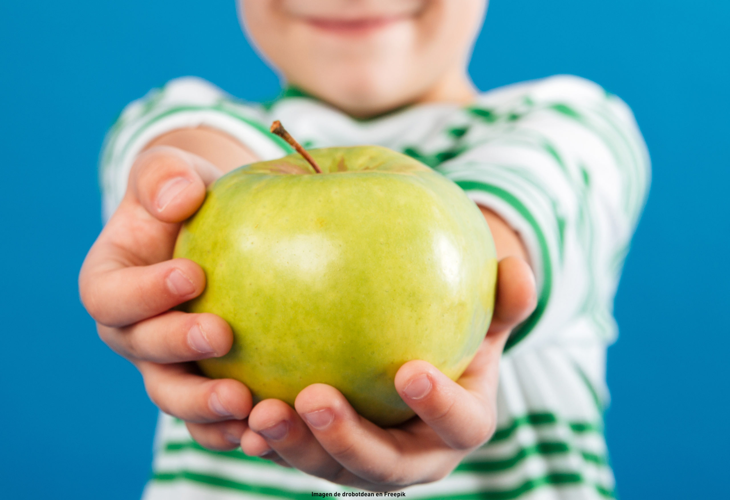 Menor mostrando una manzana verde